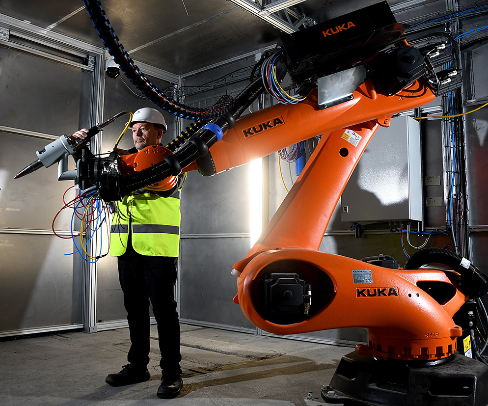 Colleague with large orange robotic arm